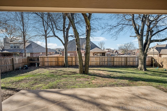 view of yard with a patio, a fenced backyard, and a residential view