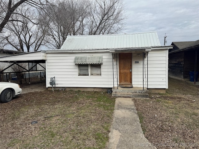 bungalow-style house with metal roof and an attached carport