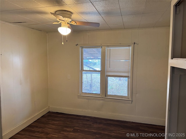 spare room featuring dark wood-style floors, baseboards, and a ceiling fan