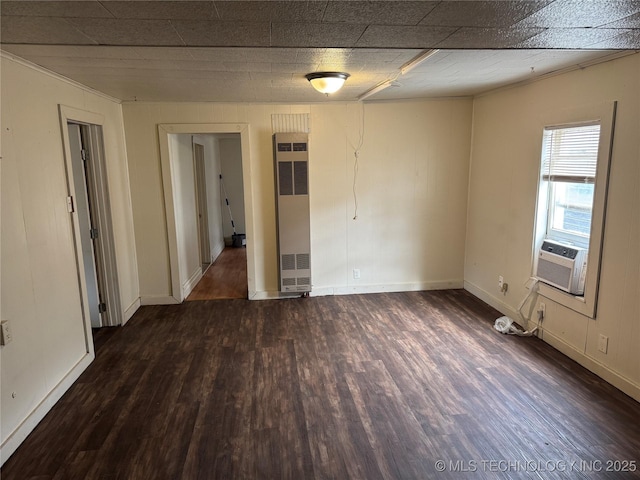 spare room featuring wood finished floors, cooling unit, and baseboards