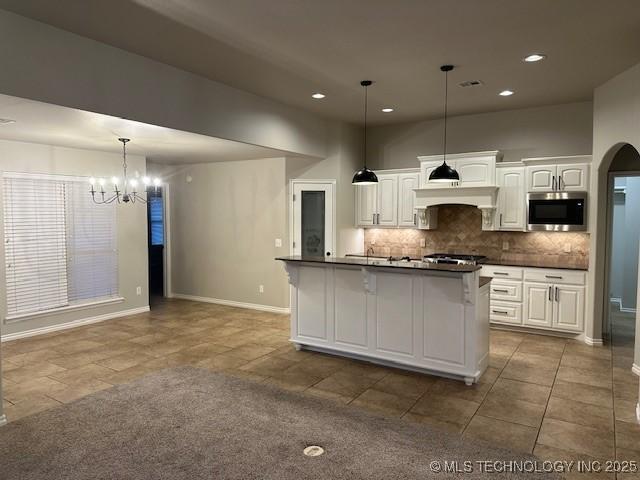 kitchen featuring dark countertops, white cabinetry, and stainless steel microwave