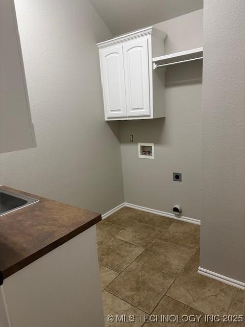 washroom featuring hookup for a washing machine, cabinet space, electric dryer hookup, and baseboards