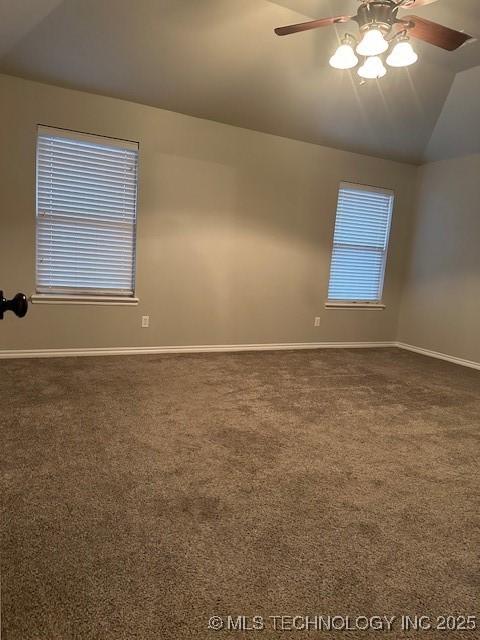 unfurnished room with carpet floors, baseboards, vaulted ceiling, and a ceiling fan