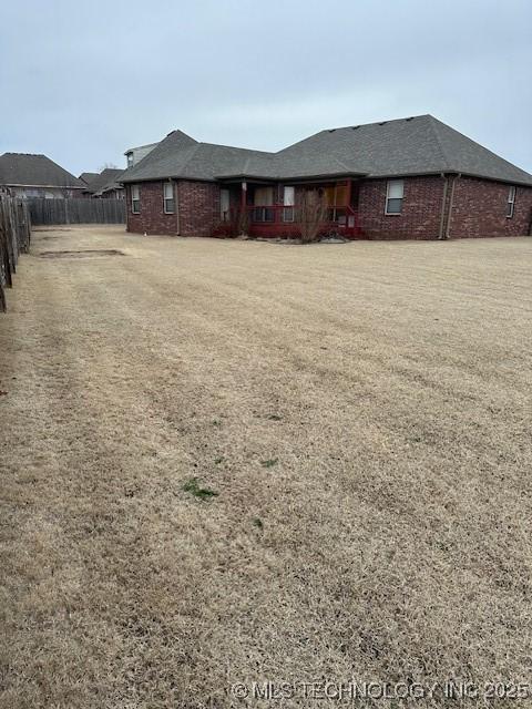 back of property with fence and brick siding