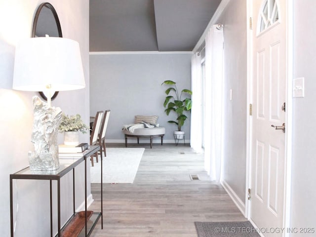 hall featuring baseboards and wood finished floors