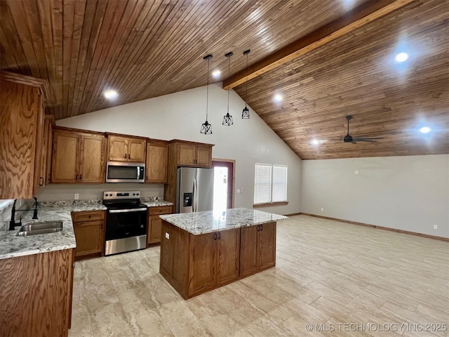 kitchen with brown cabinetry, a kitchen island, appliances with stainless steel finishes, decorative light fixtures, and a sink