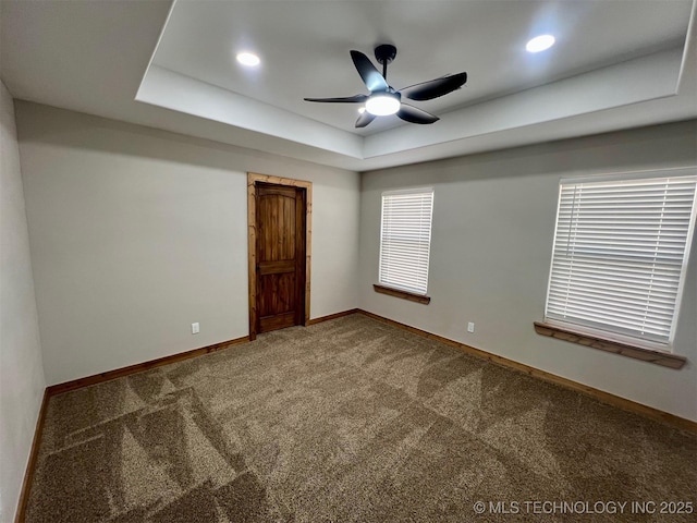 unfurnished room with baseboards, a ceiling fan, a tray ceiling, carpet floors, and recessed lighting