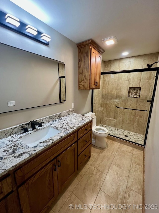 full bath with vanity, a shower stall, and toilet