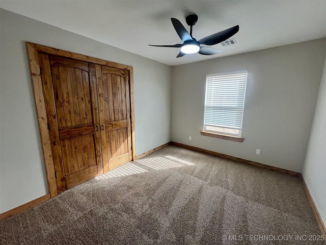 unfurnished bedroom featuring carpet floors, baseboards, visible vents, and a ceiling fan