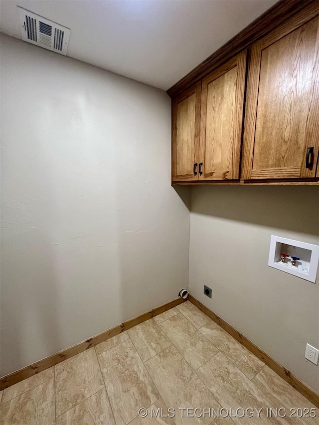 clothes washing area featuring washer hookup, visible vents, cabinet space, and baseboards