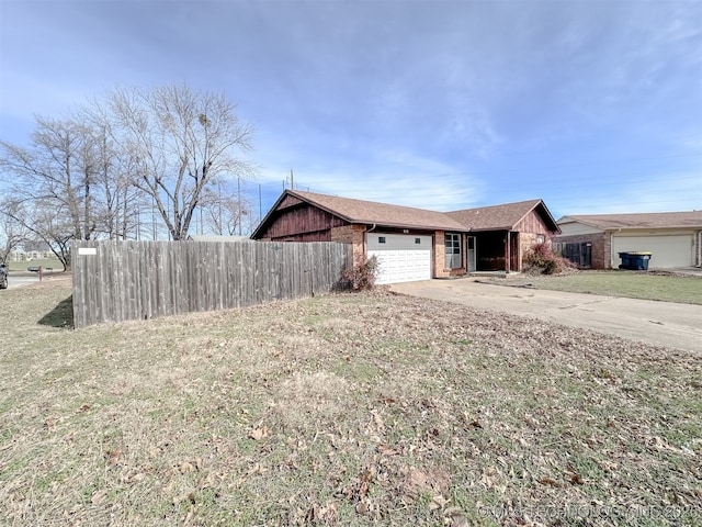 view of front of home featuring brick siding, an attached garage, fence, driveway, and a front lawn