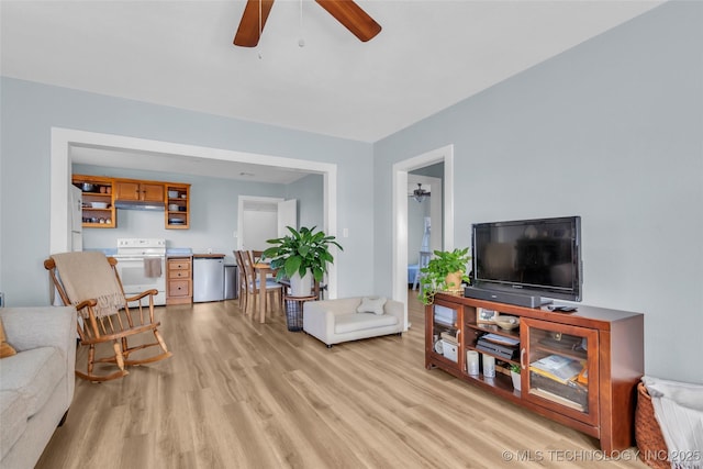 living area with light wood-style floors and a ceiling fan