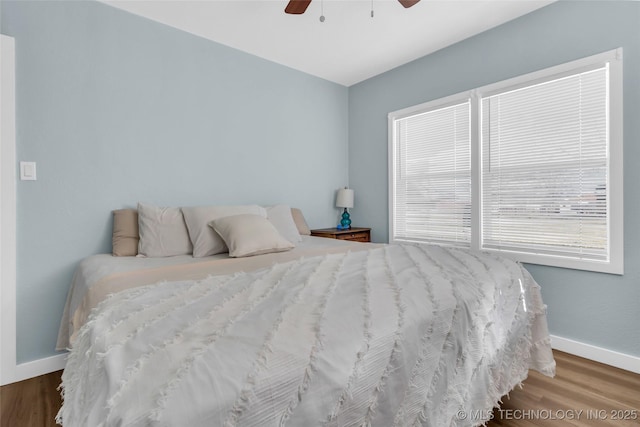 bedroom featuring ceiling fan, wood finished floors, and baseboards