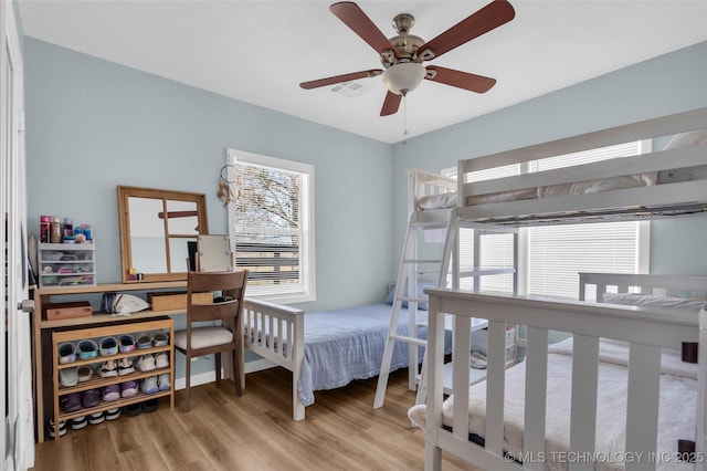 bedroom featuring light wood finished floors, ceiling fan, multiple windows, and visible vents