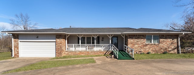 single story home featuring a porch, concrete driveway, and brick siding