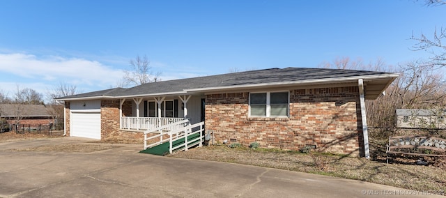 ranch-style home featuring a porch, an attached garage, brick siding, concrete driveway, and crawl space