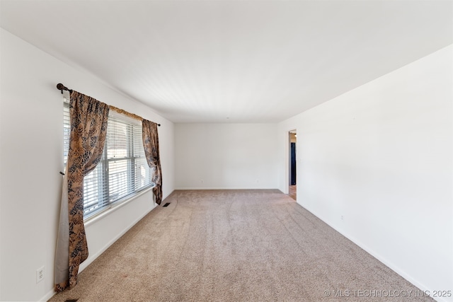 empty room with light carpet and baseboards