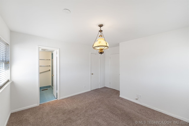 carpeted empty room with baseboards