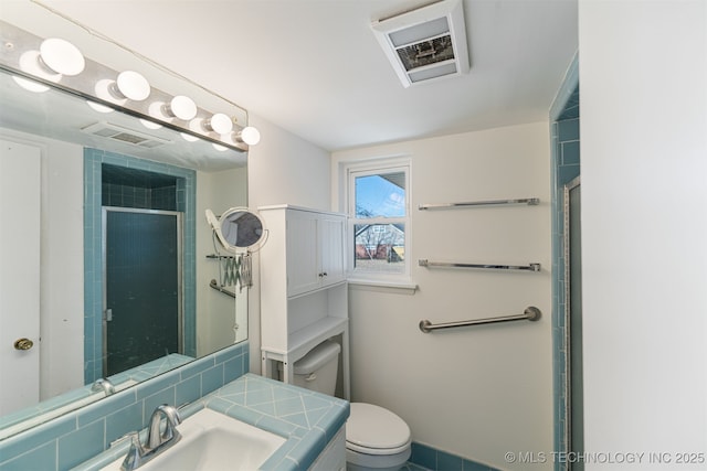 bathroom with a shower with door, a sink, visible vents, and toilet