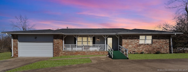 single story home with concrete driveway, a porch, an attached garage, and brick siding