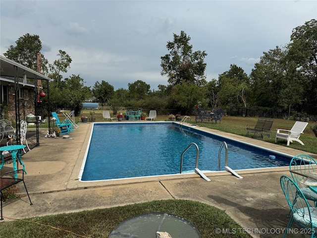 community pool with a patio and a lawn