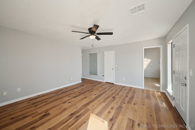 unfurnished bedroom featuring visible vents, ceiling fan, baseboards, and wood finished floors