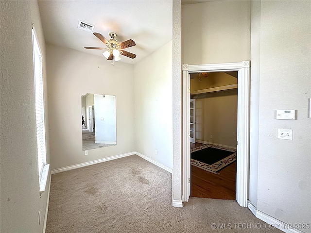 unfurnished bedroom featuring a ceiling fan, baseboards, visible vents, and carpet flooring