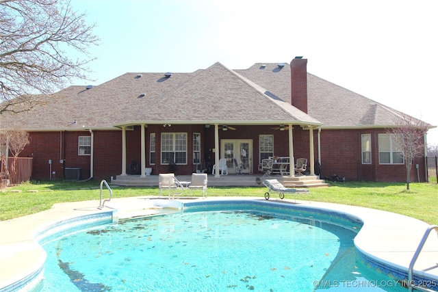 outdoor pool with a lawn, central AC, fence, a deck, and ceiling fan