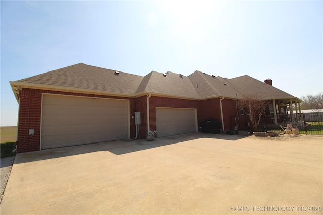 ranch-style home featuring a garage, brick siding, fence, driveway, and roof with shingles