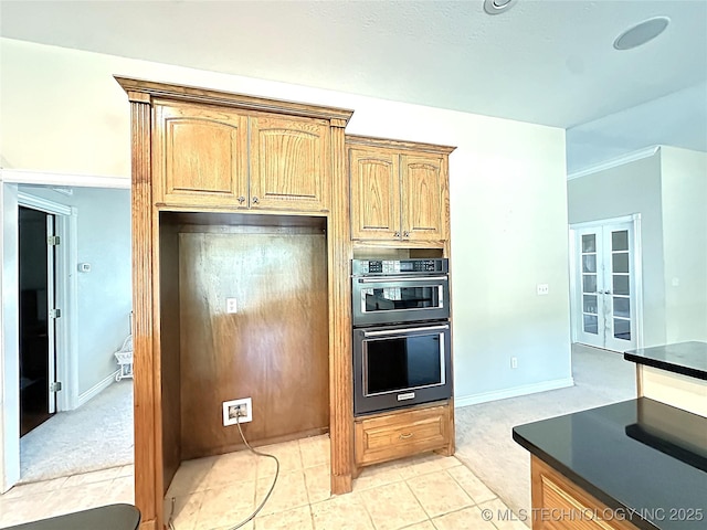 kitchen featuring dobule oven black, light tile patterned floors, baseboards, dark countertops, and french doors