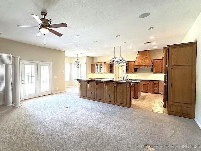 kitchen featuring brown cabinets, a center island, premium range hood, and light carpet