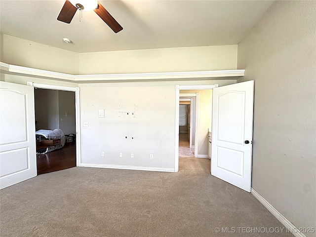 unfurnished bedroom with carpet floors, baseboards, and a ceiling fan