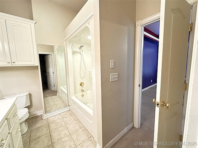 bathroom with toilet, vanity, baseboards, tile patterned floors, and washtub / shower combination