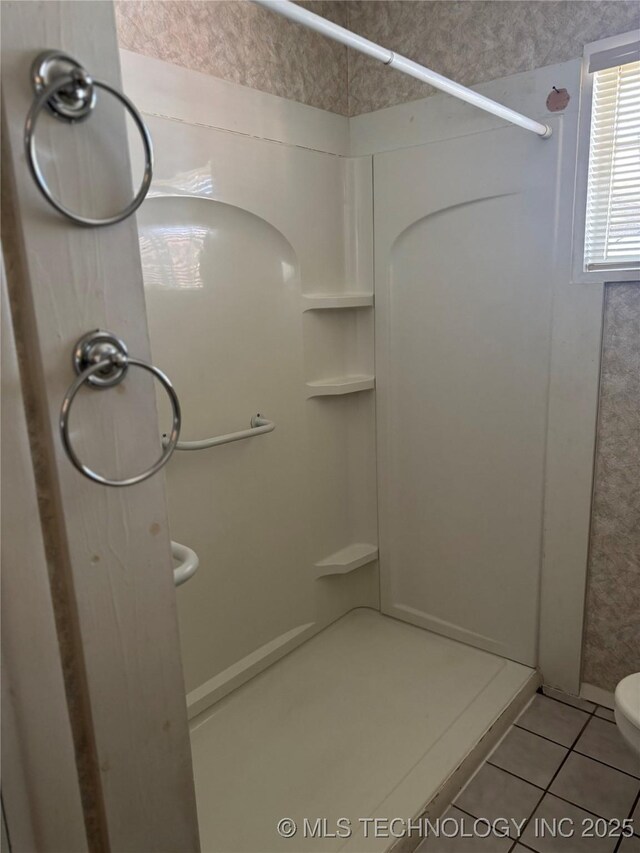 full bathroom featuring toilet, a shower stall, and tile patterned flooring