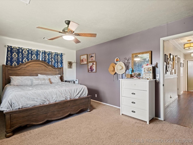 bedroom with baseboards, light colored carpet, attic access, and ceiling fan