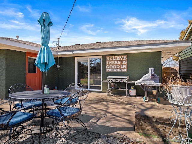 view of patio with outdoor dining area, a grill, and fence