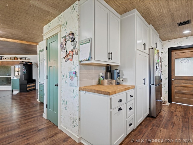 kitchen with butcher block counters, wooden ceiling, freestanding refrigerator, white cabinets, and dark wood-style flooring