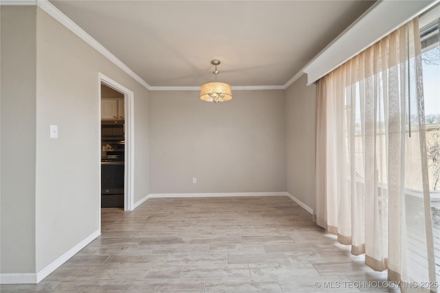 empty room featuring light wood finished floors, baseboards, and ornamental molding