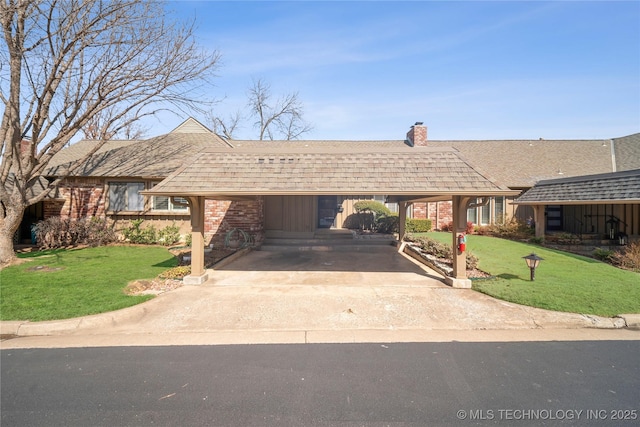 ranch-style home featuring brick siding, concrete driveway, a front lawn, and roof with shingles