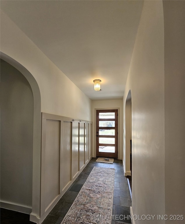 doorway with stone tile floors and arched walkways