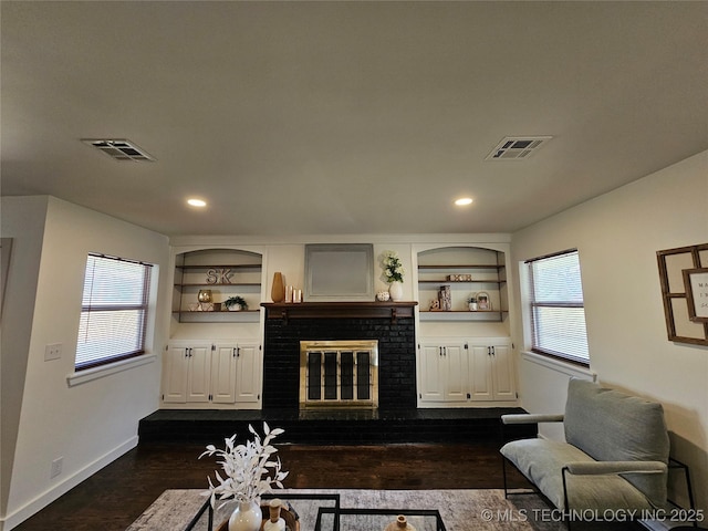 living area featuring built in features, a healthy amount of sunlight, and visible vents