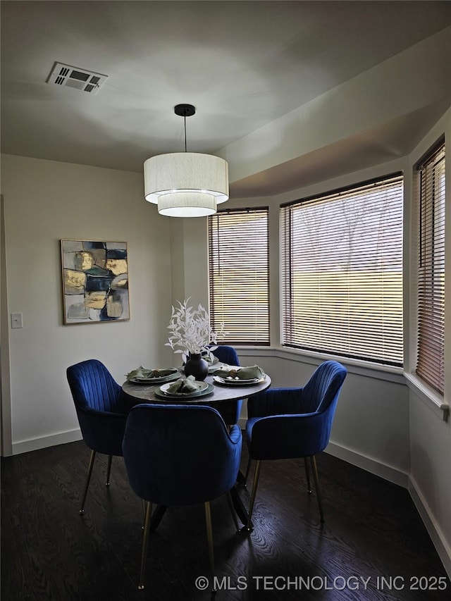 dining area with visible vents, baseboards, and wood finished floors