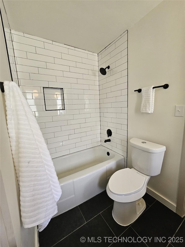 bathroom featuring tile patterned floors, toilet, baseboards, and bathing tub / shower combination