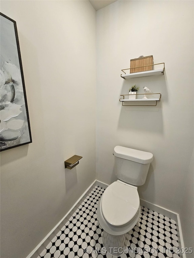 bathroom featuring toilet and baseboards