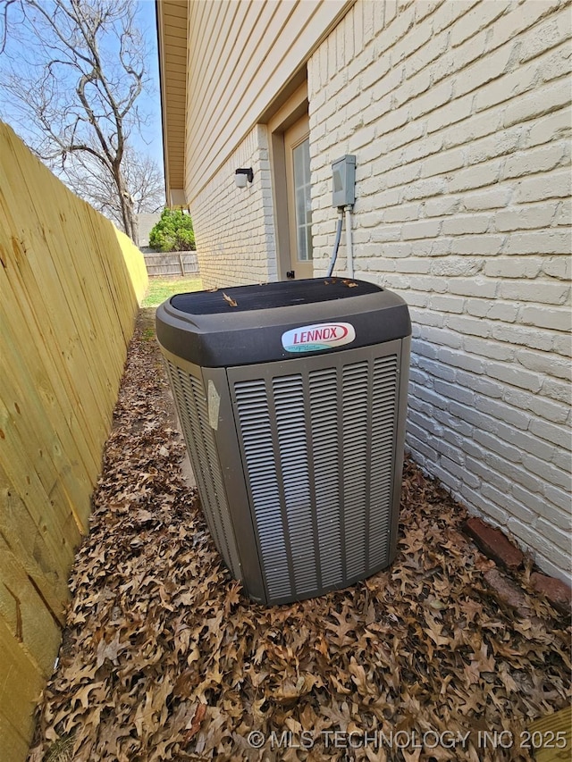 details with brick siding, central air condition unit, and a fenced backyard