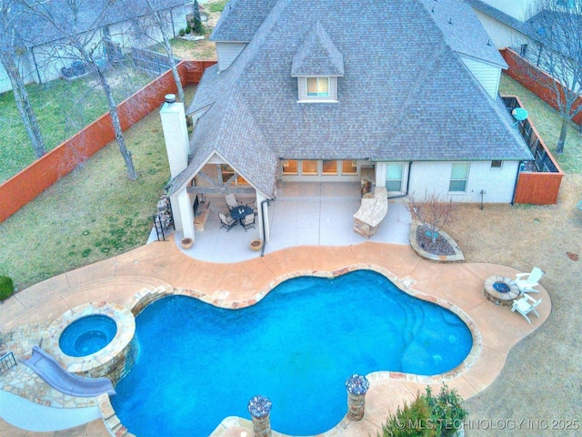 view of pool with a patio area, a fenced backyard, a pool with connected hot tub, and outdoor dry bar