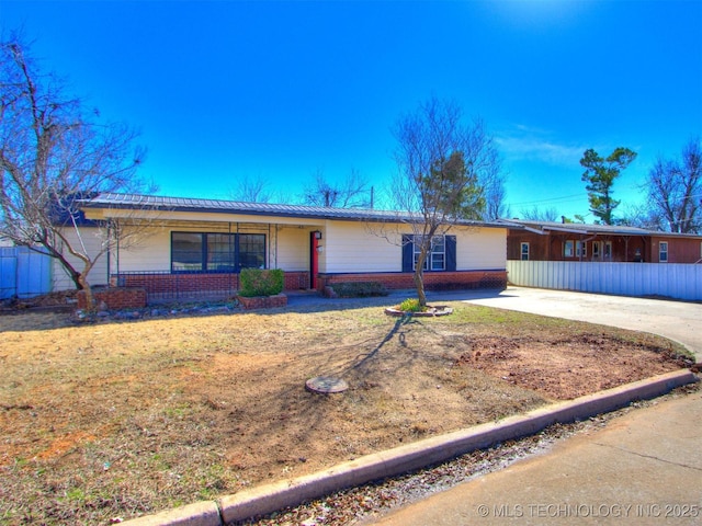 ranch-style home featuring concrete driveway, brick siding, and a front lawn