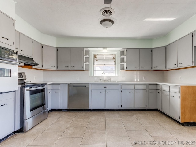 kitchen with under cabinet range hood, visible vents, appliances with stainless steel finishes, gray cabinets, and open shelves