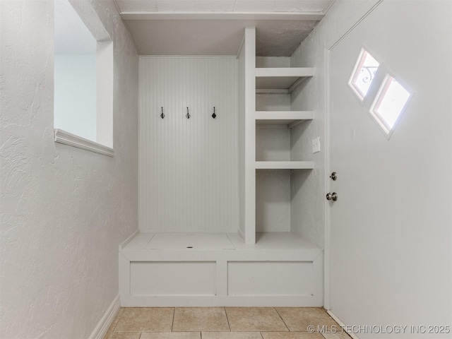 mudroom featuring light tile patterned floors and a textured wall