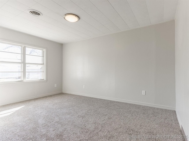 carpeted empty room featuring visible vents and baseboards